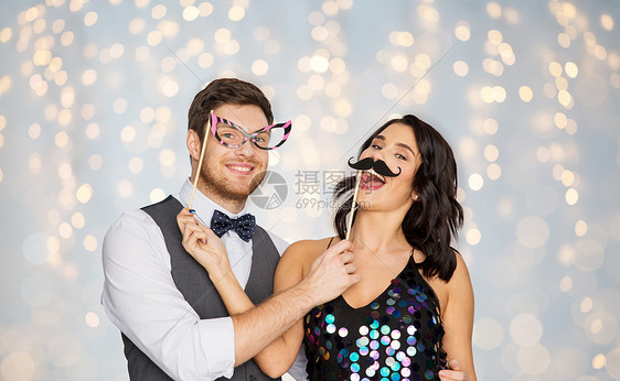 庆祝,乐趣节日的快乐的夫妇与派道具节日灯的背景快乐的夫妇派道具玩得开心图片