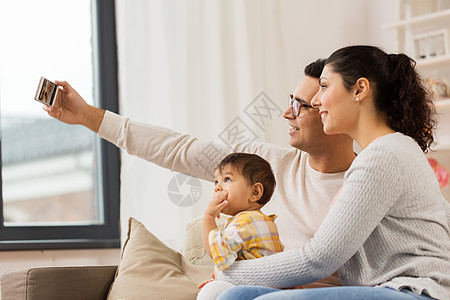 家庭,技术,父母人的快乐的母亲父亲与婴儿女儿家里用智能手机自拍妈妈爸爸带着宝宝家自拍图片