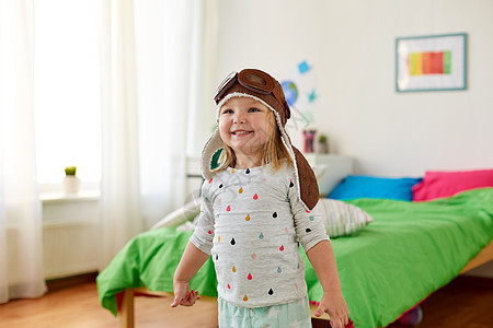 童,想象梦想的快乐的小女孩飞行员帽子玩游戏家快乐的小女孩戴着领航帽家玩图片