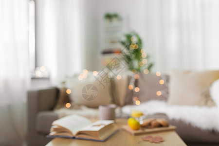 潮湿舒适的家庭模糊的背景客厅与书,杯茶食物桌子沙发上模糊舒适的客厅背景图片