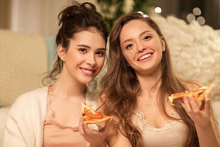 美食睡衣派的快乐的女朋友十几岁的女孩家吃比萨饼快乐的女朋友家吃披萨图片