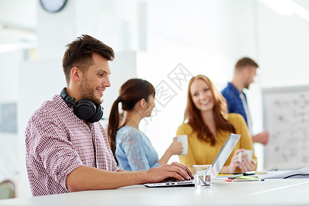 商业,教育,技术人的快乐的创意人学生戴着耳机笔记本电脑办公室创造力的人办公室带耳机笔记本电脑图片