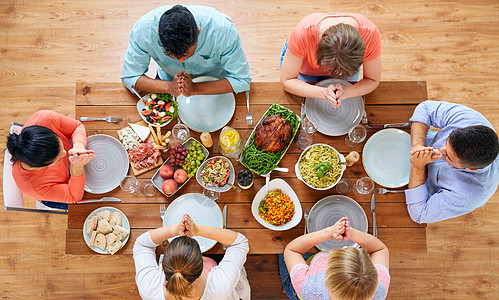 感恩节,食物宗教群人坐桌子前祈祷群人饭前祈祷图片