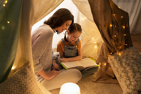 快乐的母亲孩子们帐篷里快乐的看家庭读物图片