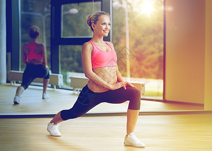 健身,运动,训练,健身房生活方式的微笑的女人伸展腿健身房微笑的女人健身房伸展腿图片