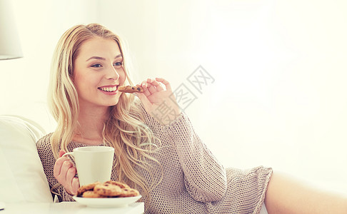 早上,休闲人们的快乐的轻女人,喝杯咖啡茶,家里的卧室床上吃饼干快乐的女人家里床上喝咖啡饼干图片