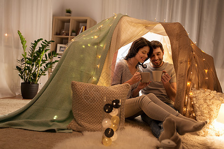 休闲,潮湿人们的快乐的夫妇孩子们的帐篷里喝咖啡茶夫妇家孩子们的帐篷里喝咖啡茶图片