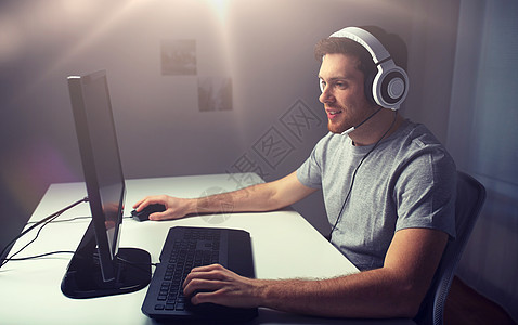 技术,游戏,娱乐活动,让们的游戏人的快乐的轻人耳机与个人电脑玩游戏家里流媒体播放演练视频戴耳机的男人家玩电图片