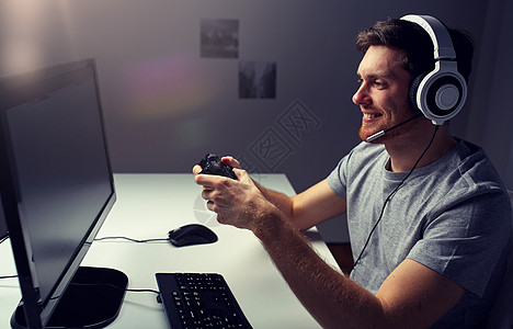 技术,游戏,娱乐活动,让们的游戏人的快乐的轻人耳机与控制器游戏家里玩电脑游戏流媒体播放演练视频戴耳机的男人图片
