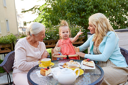 家庭,世代人的快乐的母亲,女儿祖母咖啡馆餐厅露台咖啡馆的母亲女儿祖母图片