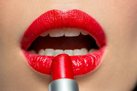 美丽,化妆化妆品的特写的脸,女人涂红色口红她的嘴唇特写女人嘴唇上涂红色口红图片