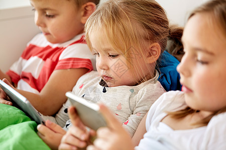 童,技术家庭小孩子与平板电脑智能手机床上家家里平板电脑智能手机的孩子躺床上图片