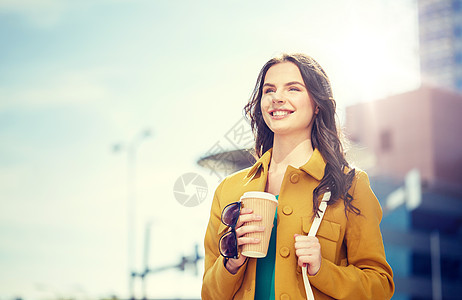 饮料人们的快乐的轻妇女十几岁的女孩喝咖啡纸杯城市街道快乐的轻女人城市街道喝咖啡图片