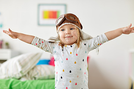 童,想象梦想的快乐的小女孩飞行员帽子玩游戏家快乐的小女孩戴着领航帽家玩图片