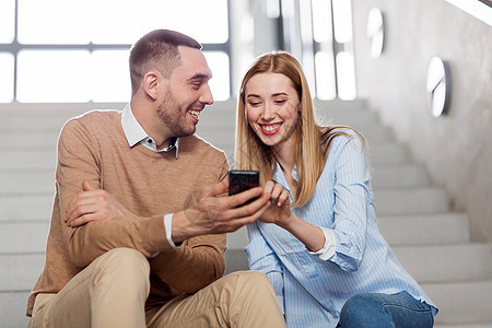 商业,技术企业微笑的男人女人与智能手机办公室楼梯办公室楼梯上智能手机的男人女人图片
