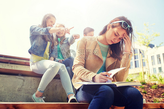 教育,欺凌,高中,社会关系人的快乐的学生女孩与书中的同学遭受嘲弄学生女孩遭受同学嘲笑学生女孩遭受同学嘲笑图片