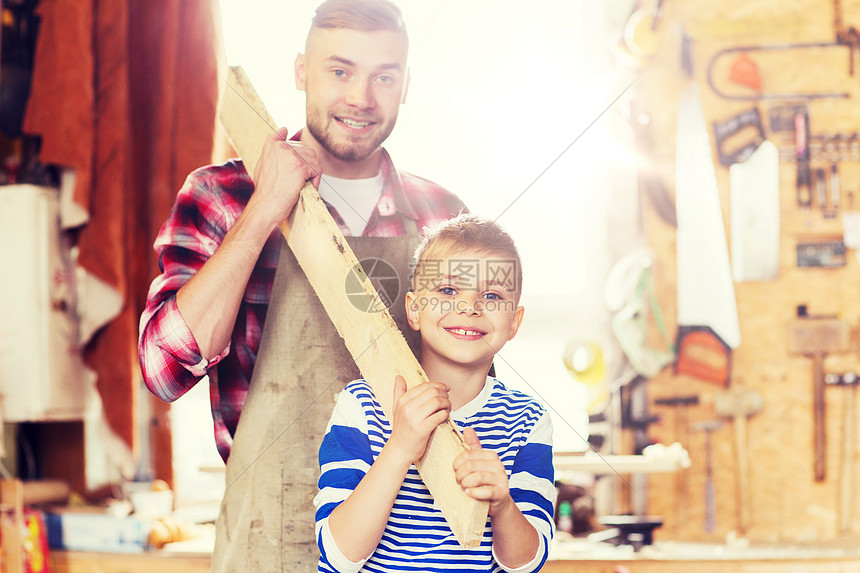 家庭,木工,木制品人的快乐的父亲小儿子车间搬运木板快乐的父子车间用木板快乐的父子车间用木板图片