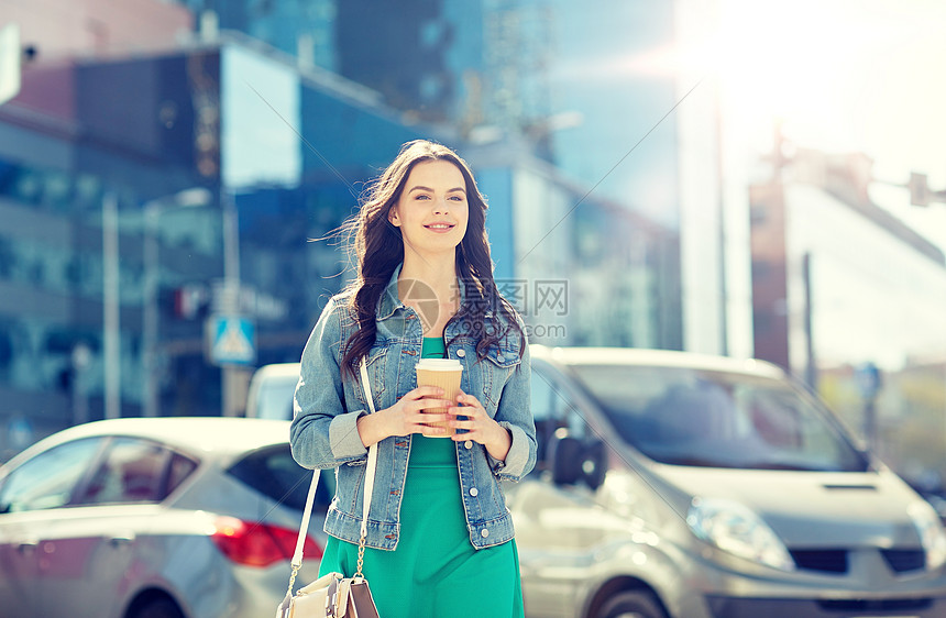 饮料人们的快乐的轻妇女十几岁的女孩喝咖啡纸杯城市街道快乐的轻女人城市街道喝咖啡快乐的轻女人城市街图片