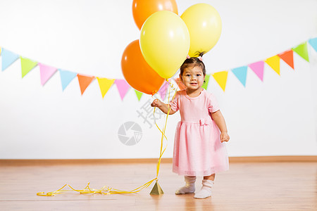 童,人庆祝快乐的女婴与氦气球生日聚会上生日派上带气球的快乐女婴生日派上带气球的快乐女婴图片