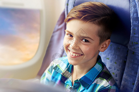 交通,旅游,公路旅行人们的快乐的男孩乘飞机舷窗背景下旅行快乐的男孩乘飞机旅行快乐的男孩乘飞机旅行图片
