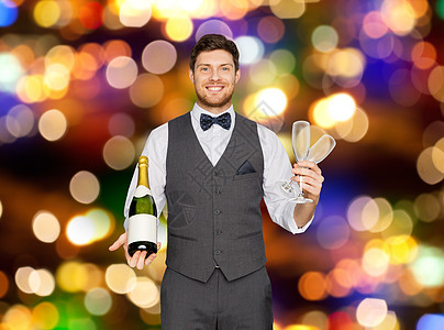 庆祝,酒精假日快乐的男人服务员聚会上着瓶香槟酒杯节日的灯光背景下派上着瓶香槟眼镜的男人派上图片