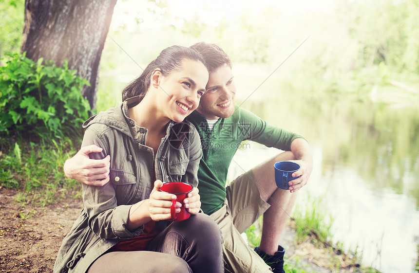 旅行,旅游,徒步旅行,野营人们的幸福的夫妇与杯子喝茶大自然的河岸幸福的夫妇喝着杯子大自然中幸福的夫妇喝着杯子图片