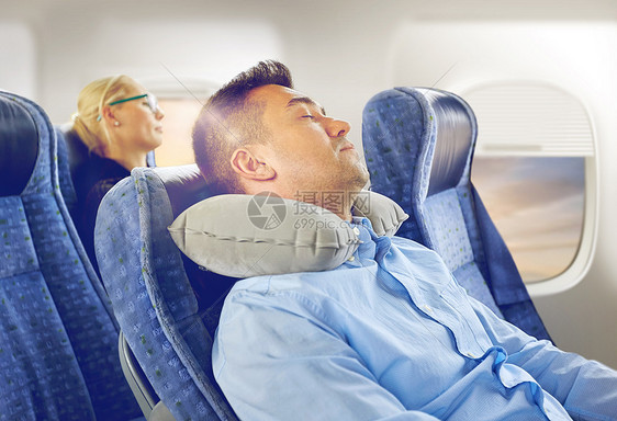 旅行,舒适人的男人睡飞机上充气颈枕舷窗背景用颈枕睡飞机上的男人用颈枕睡飞机上的男人图片