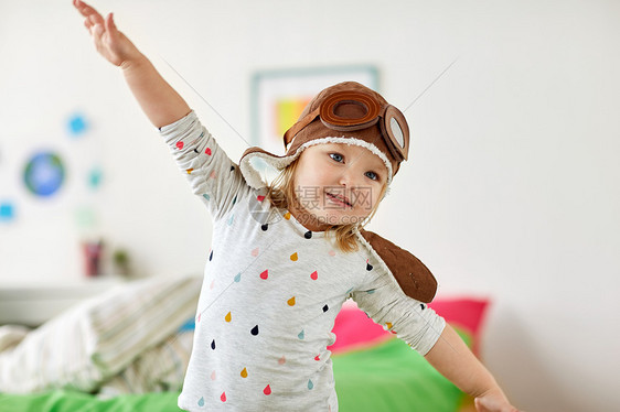 童,想象梦想的快乐的小女孩飞行员帽子玩游戏家快乐的小女孩戴着领航帽家玩快乐的小女孩戴着领航帽家玩图片