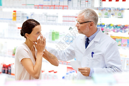 医学,医疗人的高级药剂师与药物女客户感冒鼻子药房药房的药剂师生病的顾客药房的药剂师生病的顾客图片