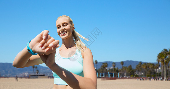 运动,技术健康的生活方式微笑的轻人与健身跟踪训练威尼斯海滩背景加利福尼亚健身追踪器的女人户外锻炼健身图片