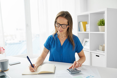 商业,人,财务会计快乐的女人与计算器计数写作笔记本办公室办公室里计算器笔记本的快乐女人办公室里计算器图片