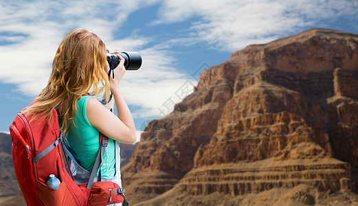 旅行,旅游摄影快乐的轻妇女背包相机拍摄大峡谷公园的背景大峡谷带背包照相机的女人大峡谷带背包照相背景图片