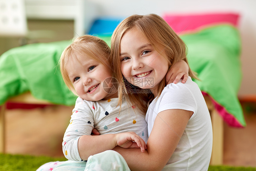 童,家庭,表情人的快乐的小女孩姐妹拥抱家里快乐的小女孩姐妹家里拥抱快乐的小女孩姐妹家里拥抱图片