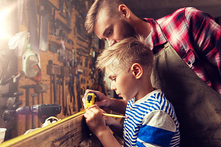 家庭,木工,木工人的父亲小儿子用尺子铅笔测量车间的木板父子用尺子车间测量木材父子用尺子车间测量木材图片