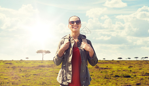 旅行,旅游人的快乐的轻妇女戴着太阳镜,背包非洲热带草原背景带着背包非洲旅行的快乐女人带着背包非洲旅行的快图片