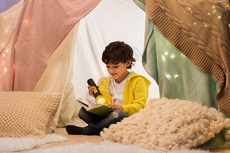 童,潮格人的快乐的男孩阅读书与火炬光孩子帐篷帐篷家里快乐的男孩家孩子们的帐篷里看书快乐的男孩家孩图片
