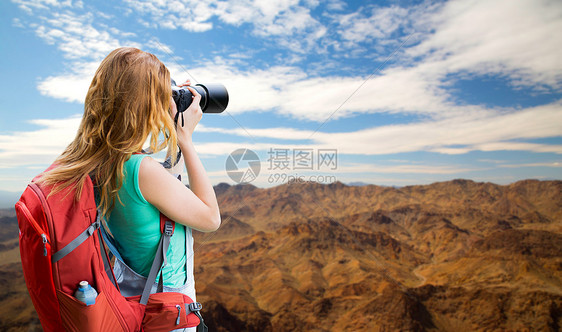 旅行,旅游摄影快乐的轻妇女背包相机拍摄大峡谷公园山丘背景大峡谷带背包照相机的女人大峡谷带背包照图片