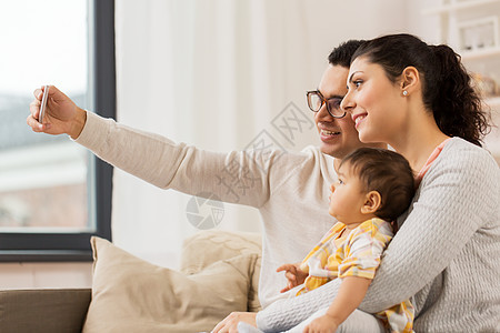 家庭,技术,父母人的快乐的母亲父亲与婴儿女儿家里用智能手机自拍妈妈爸爸带着宝宝家自拍妈妈爸爸带着宝宝图片