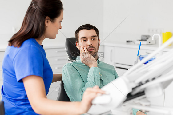 医学,牙科医疗保健女牙医牙科诊所办公室与男抱怨牙痛牙痛病人牙医办公室牙痛病人牙医办公室图片