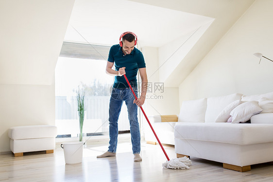 人,家务家务快乐的人耳机与拖把清洁地板家里戴耳机的男人家用拖把打扫地板戴耳机的男人家用拖把打扫地板图片