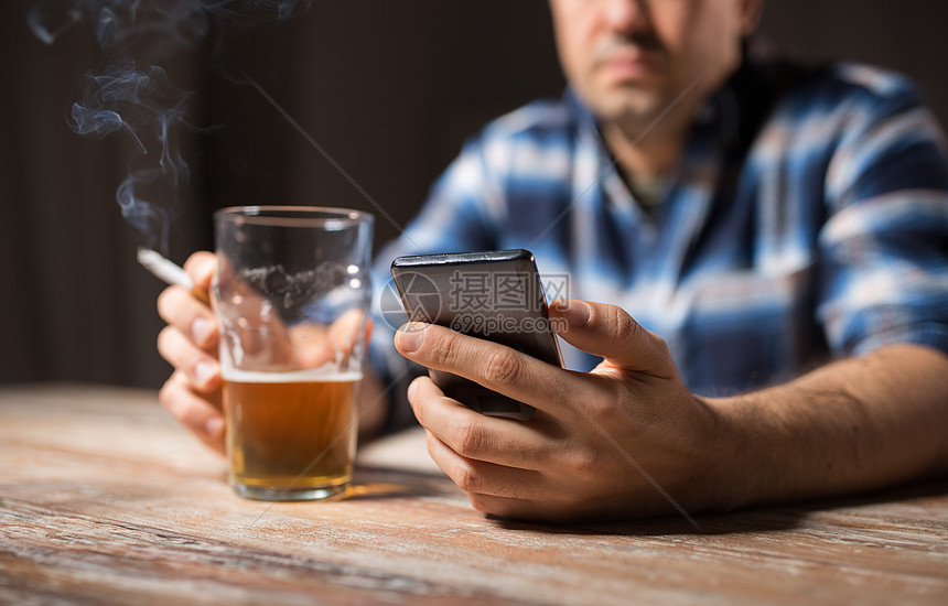 ‘~酒精中,酒精成瘾人的男酒精与智能手机喝啤酒吸烟晚上手机的男人喝酒抽烟手机的男人喝酒抽烟  ~’ 的图片