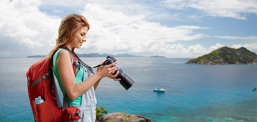 海滩上女人带着背包相机旅行摄影图片