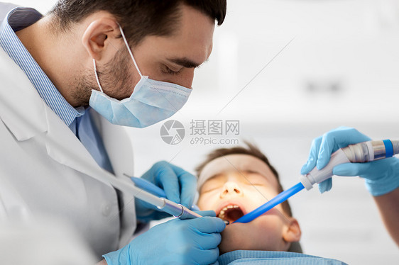 医学,牙科医疗牙科医生助理与牙科钻唾液喷射器治疗儿童患者牙齿牙科诊所牙医牙科诊所治疗儿童牙齿牙医牙科诊图片