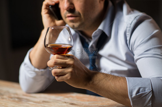 酒精中,酒精成瘾人们的密切男酒精饮用白兰地打电话智能手机晚上酒精的人打电话酒精的人打电话图片