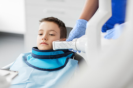 医学,牙科医疗女牙医与X光机扫描儿童病人牙齿牙科诊所牙医牙科诊所儿童牙齿的X光牙医牙科诊所儿童牙齿的背景图片