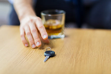 酗酒,醉酒驾驶人的男司机的手与威士忌璃桌子上车钥匙把酒精汽车钥匙放桌子上把酒精汽车钥匙放桌子图片