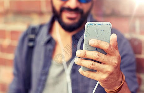 人技术近距离的人与耳机智能手机听音乐砖墙街上带耳机智能手机的男人街上带耳机智能手机的男人街上图片