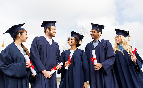 教育毕业人的群快乐的国际学生穿着迫击炮板学士学位礼服与文凭文凭的迫击炮板上快乐的学生文凭的迫击炮板上快图片