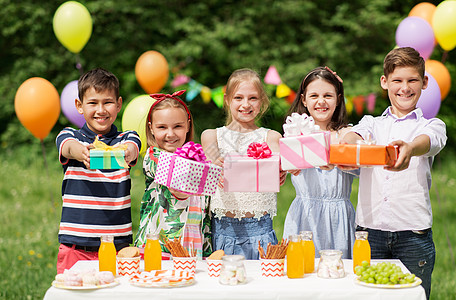 假期,童庆祝快乐的孩子生日聚会上夏季花园快乐的孩子夏天的生日聚会上带着礼物快乐的孩子夏天的生日聚会上带图片