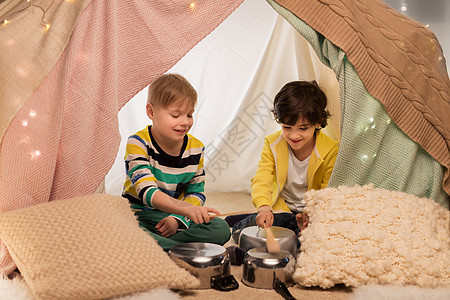 童潮湿的快乐的小男孩与烹饪锅播放音乐孩子帐篷家里孩子们家里的帐篷里着罐子放音乐孩子们家里的帐篷里着图片